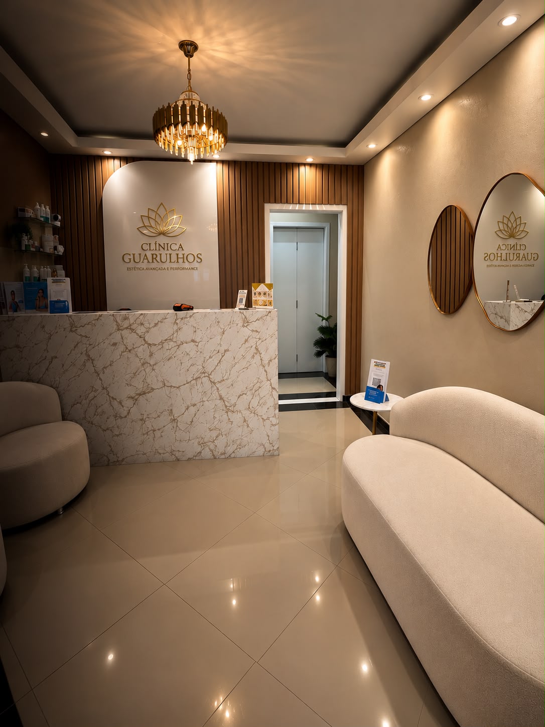 Recepção da clínica com balcão de mármore e poltronas creme